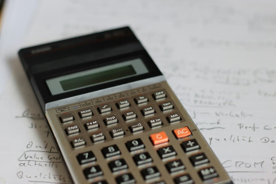 Une calculatrice posée sur des notes manuscrites pour comparer le prix des offres Xenon IPTV